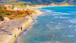 beach background with turquoise sea water waves and umbrellas greece