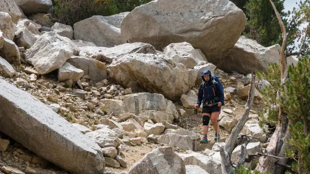 Female backpacker hikes during a rain storm in the mountains