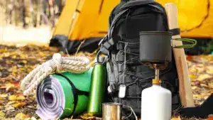 tourists survival kit and camping tent in autumn forest