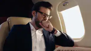 businessman yawning near newspaper in private plane