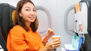 happy woman ordered tasty breakfast during flight in the plane